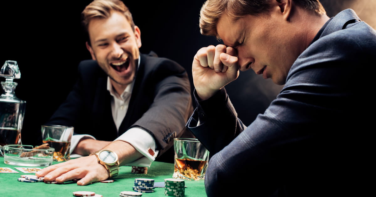 A frustrated man at the poker table, a happy man grabbing the poker chips